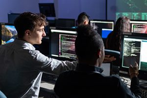 Cybersecurity students at their computer workstations